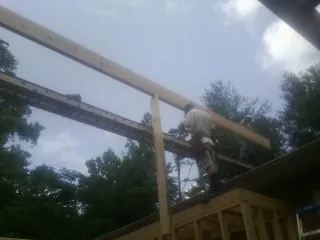 Carpenter setting a ridge beam over a new addition frame — Ice Dam Removal by Roofing Brothers in Willington