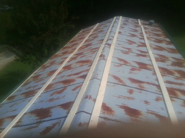Rusted metal roof panels with new wood purlins before replacement — Storm Damage Roof Repair in Willington by Roofing Brothers