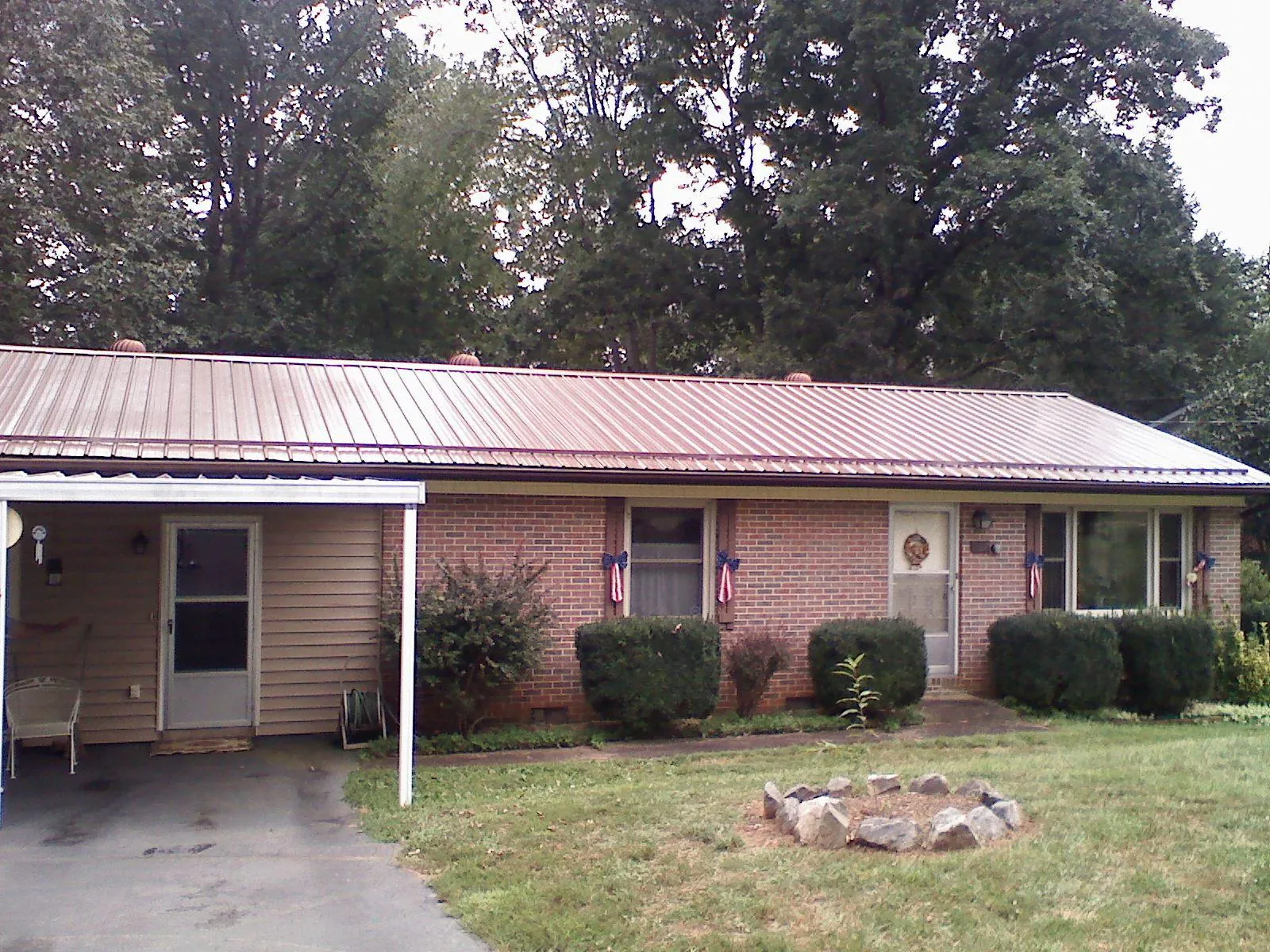 Bronze metal roof and carport on a brick ranch home — Roof Repair work by our crew in Willington